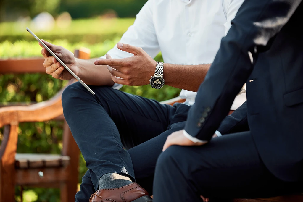 Two people in business attires talking in a park