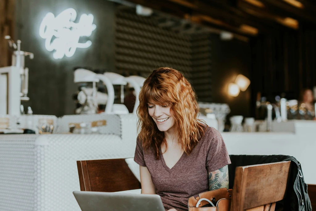 woman opens cold email in coffee shop