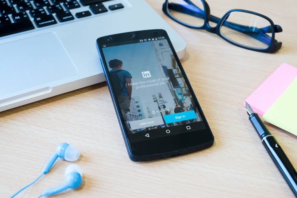A phone on the desk with LinkedIn app opened